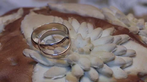 Two splendid wedding rings on Almond banana bread isolated on white background Stock Footage 62817115