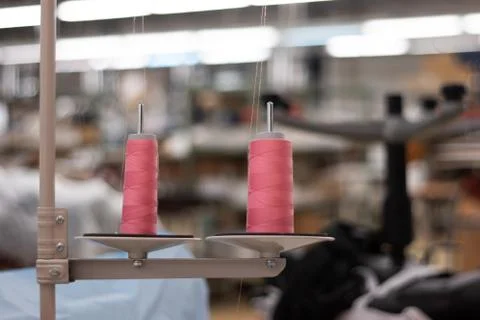 Two spools of pink sewing thread mounted on industrial machine inside out of  Fotos de archivo
