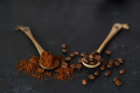 Two spoons with coffee on a black background. Stock Photos