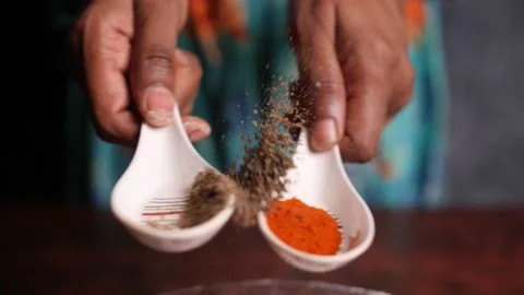 Two spoons with pepper powder and chilly powder clashing against each other Stock Footage 132976346