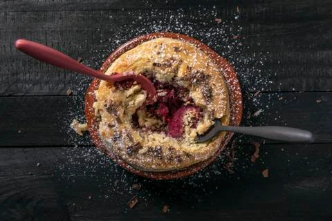 Two spoons stuck in a raspberry pie. Tasty dessert eating. Above view. Stock Photos