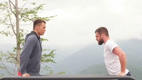 Two sportsmen doing dips on parallel bars 動画素材 99364775