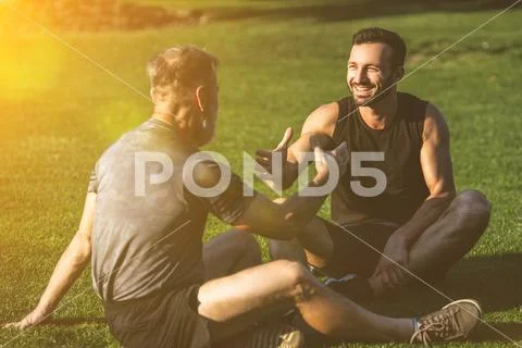 The two sportsmen handshaking on the grass on the sunny background Stock Photos
