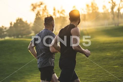 The two sportsmen running on the grass Stock Photos