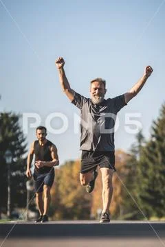 The two sportsmen running on the park road Stock Photos