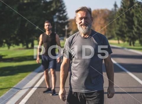The two sportsmen standing on the road in the park Stock Photos