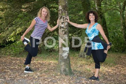 Two sportswomen stretching and preparing to run. Stock Photos