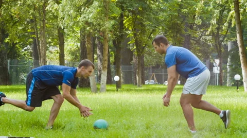 Two sporty man or instructors doing gymnastic exercise outdoor Stock Footage 65764067