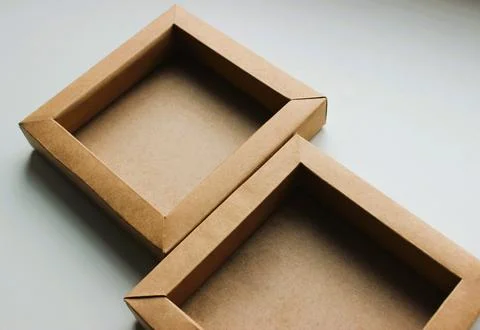 Two Square Cardboard Trays Fitted to Each Other on a White Table Stock Photos