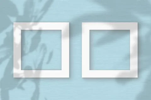 Two square frame sheet of white textured paper on the blue wall background. M Stock Illustration