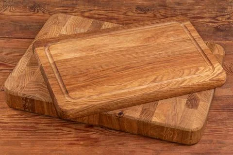 Two stacked different natural oak cutting boards on rustic table Stock Photos