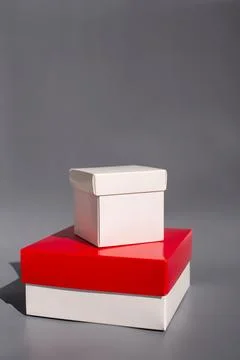 Two stacked gift boxes on gray background with light shadows Stockfoto's