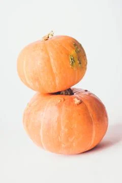 Two stacked mini pumpkins on white background. Stock Photos
