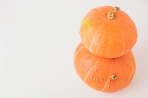 Two stacked mini pumpkins on white background. Stock Photos