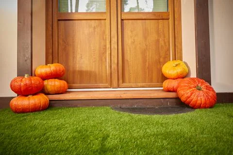 Two stacks of large orange pumpkins At the door of the house. Autumn harvest and Stock Photos