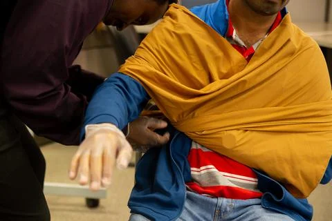 Two staff training to give first aid to arm with broken bones Stock Photos