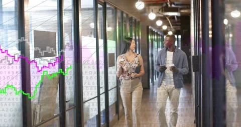 Two staff walking to camera in office, nearing causing data graphs growing on Video stock 332401925