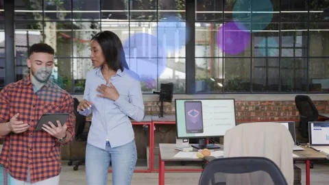 Two staff walking office, tablet tapping creating color dots over desks, pausing Stock Footage 332934405