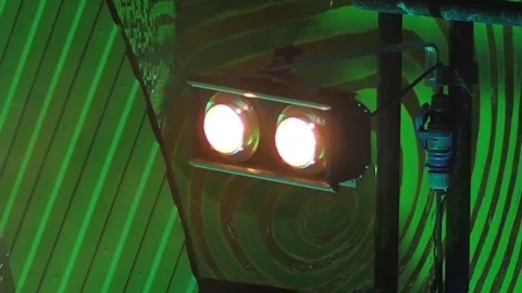Two stage lights are blinking against a green stage background in a loop 스톡 동영상 155211122