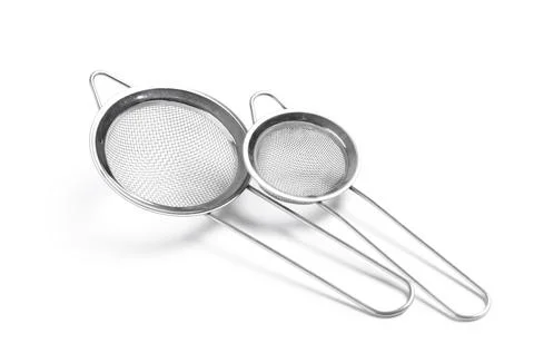 Two stainless steel kitchen strainers with fine mesh and long handles, cookin Stock Photos