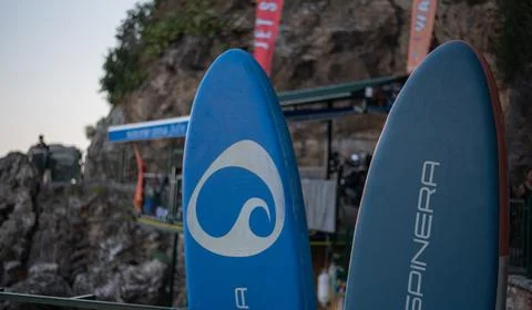 Two stand-up paddleboards, stand vertically at an outdoor rental station Stock Photos