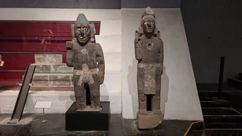 Two Standing Stone Figures Before Red Banded Wall, Templo Mayor, Mexico 8K Stock Footage 340373719