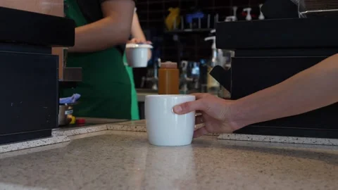 Two Starbucks workers give out order of two white cups with tea and coffee Stock Footage 142315423