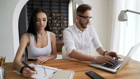Two start up partners work in workspace at desk in trendy loft close up with bac Video stock 199491405