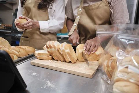 Two startup chefs live stream show, demonstrate slicing bread in the kitchen. Stock Photos