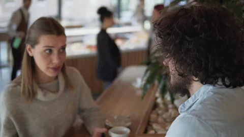 Two startup people discussing ideas during a casual meeting in a modern cafe Stock Footage 335602704