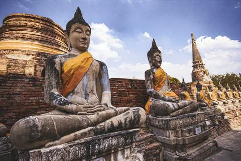 Two statues of Buddha sitting on a brick wall Stock Photos