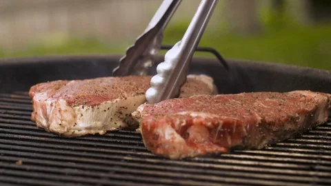 Two Steaks being Flipped on the Grill Stock Footage 91448821