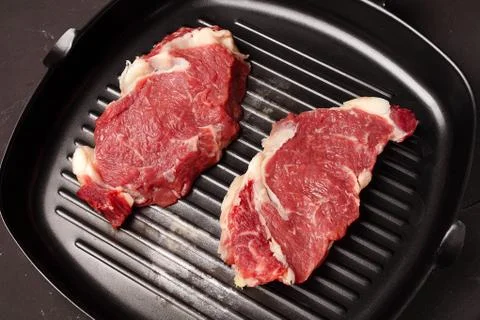 Two steaks in a pan for grilling, close-up Stock Photos