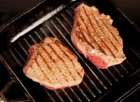 Two steaks in the pan Stock Photos