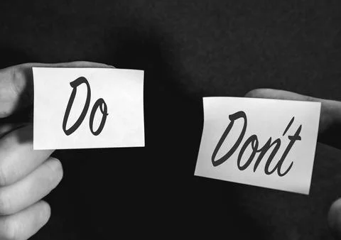 Two sticky notes on a black background, with Do's and Dont's Fotos de archivo