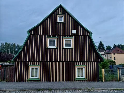 Two storey timber house with vertical striped cladding and green trim Stock Photos