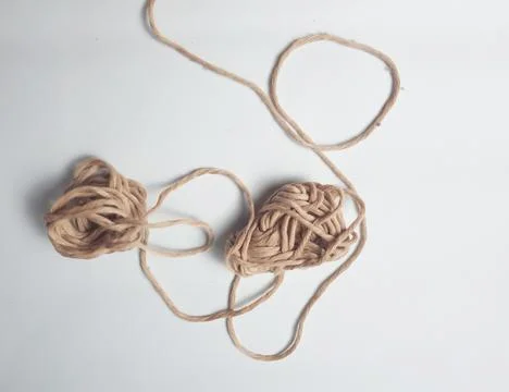Two strands of knitting thread tangle together. The thread is brown and loo.. Stock Photos