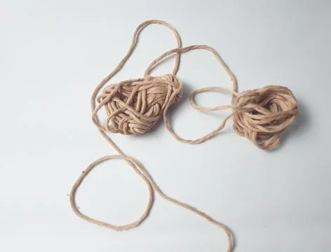 Two strands of knitting thread tangle together. The thread is brown and loo.. Stock Photos
