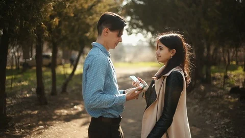Two strangers with smartphones in hands suddenly collided in the park 库存影片 105839448