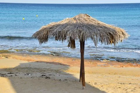 Two straw umbrellas on empty sandy beautiful beach Stock Photos