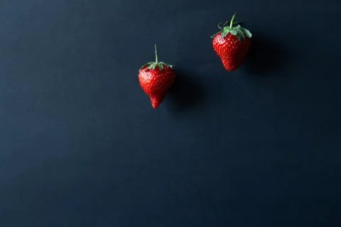Two strawberries on a black background Stock Photos