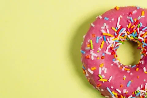 Two strawberry donuts with colored chocolate shavings on top. Stock Photos