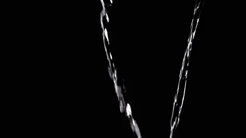 Two Streams of Water with Drops Pour into Empty Space on Black Background Stock Footage 312013397