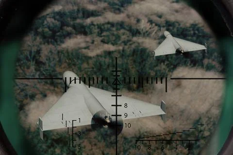 Two strike drones fly above forest area and are observed through optical scop 스톡 사진