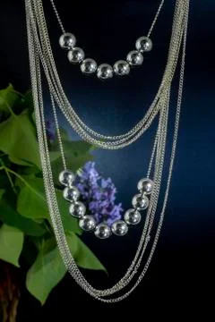 Two strings of round shiny beads and many thin chains. Stock Photos