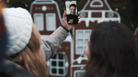 Two student girls chatting wth a friend via facetime at xmas time. Christmas 库存影片 139752053