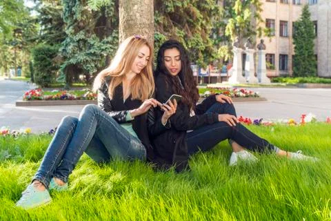 Two students are sitting on the grass Stock Photos