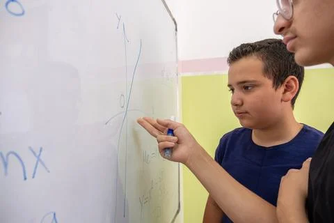 Two students are studying together using the whiteboard in school Stock Photos