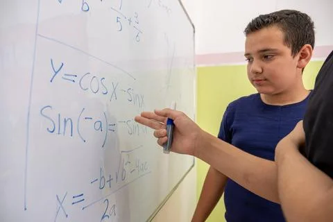 Two students are studying together using the whiteboard in school Stock Photos