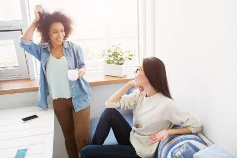 Two students are talking to each other. Afro american girl is standing near Foto stock